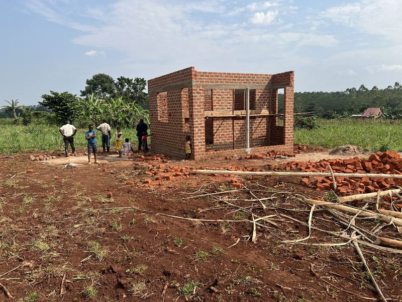 De bouw van de opslagruimte op het perceel in Jinja