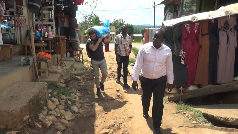 Inkopen van basisproducten op een lokale markt in Kampala voor de voedselpakketten