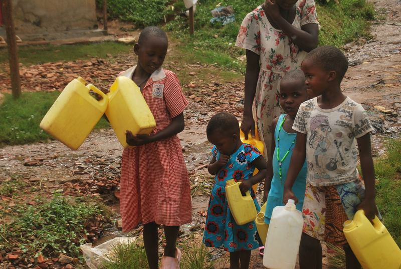Kinderen met gele jerrycans bij de waterplek in Muchanga