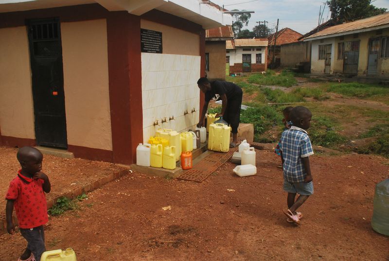 Kinderen halen water met jerrycans bij het betegelde tappunt van de waterput